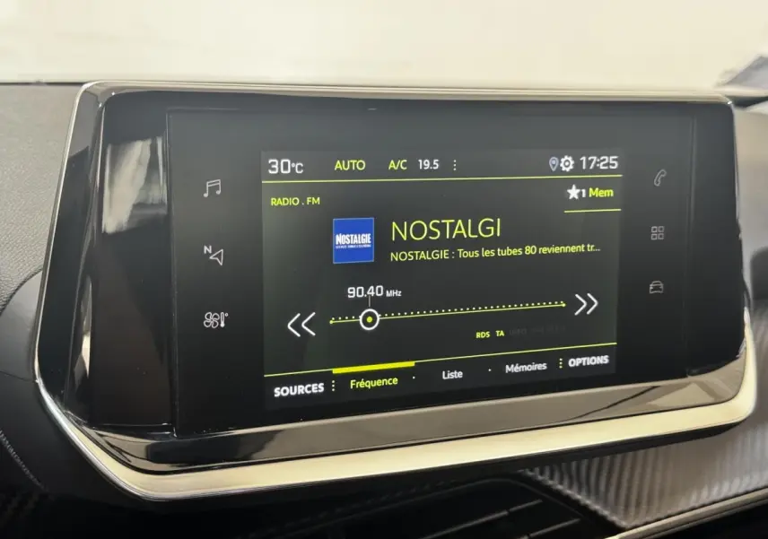 Écran tactile central du tableau de bord du Peugeot 2008 noir, affichant la radio FM sur la station Nostalgie.