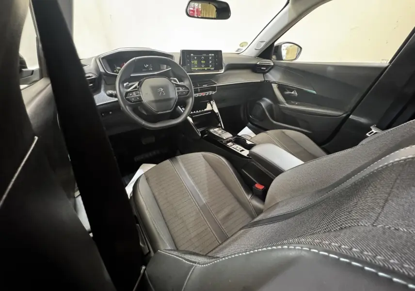 Intérieur avant droit du Peugeot 2008 noir 2022, volant cuir multifonctions et écran tactile central visible.