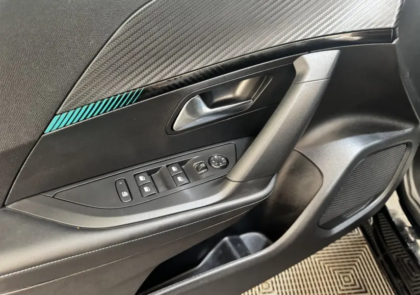 Détail de la porte avant gauche noire du Peugeot 2008 avec commandes des vitres et insert décoratif bleu.