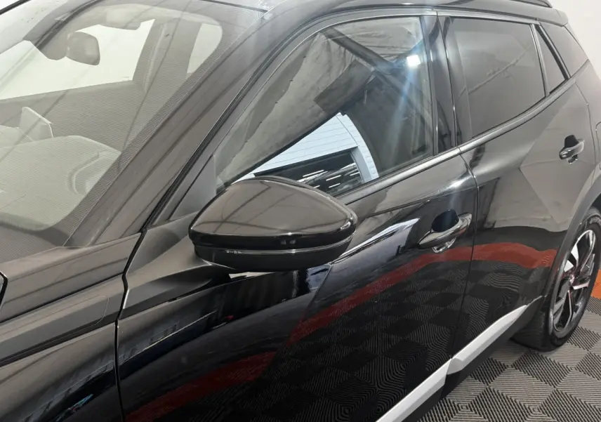 Vue latérale droite du Peugeot 2008 noir 2022 avec rétroviseur et jantes noires distinctives.