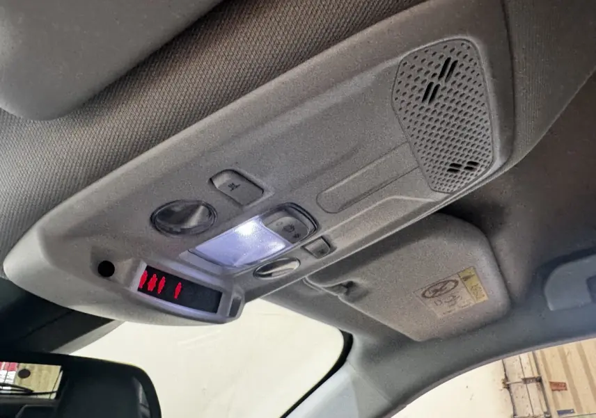 Plafonnier avant intérieur de Peugeot 2008 noir, avec éclairage LED et commandes intégrées visibles au-dessus du siège conducteur.