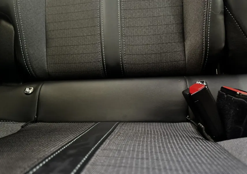 Gros plan sur la banquette arrière noire du Peugeot 2008, avec ceinture de sécurité rouge visible à droite.