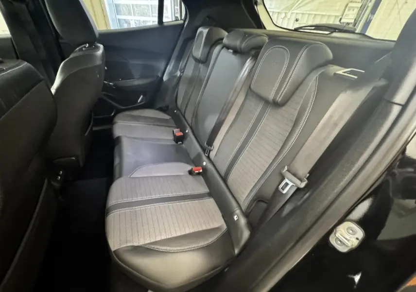 Vue intérieure côté droit montrant la banquette arrière bicolore en cuir et tissu du Peugeot 2008 noir.