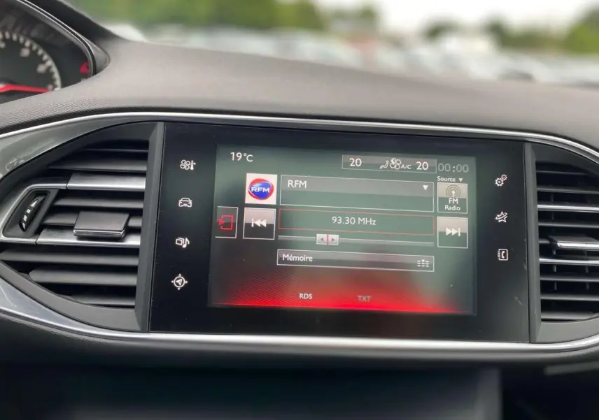 Écran tactile central de la Peugeot 308 SW 2017 affichant la radio FM avec commandes et ventilation visibles.