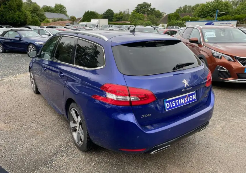 Vue 3/4 arrière droite d'une Peugeot 308 SW bleu magnétique avec feux arrière LED et double sortie d'échappement chromée.