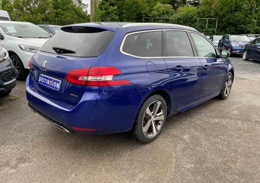 Peugeot 308 SW bleu magnétique vue 3/4 arrière droit, avec toit panoramique et jantes alliage distinctives.