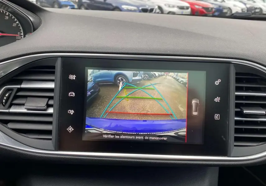 Vue de l'écran tactile de la Peugeot 308 SW bleu magnétique montrant la caméra de recul avec aides au stationnement.