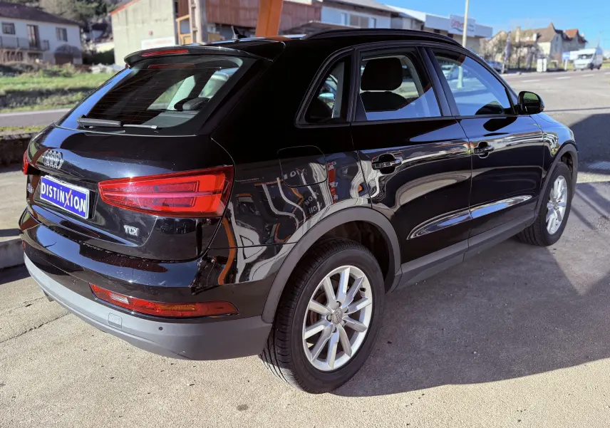 Audi Q3 noir vue 3/4 arrière droit, avec feux arrière LED et jantes alliage 17 pouces.