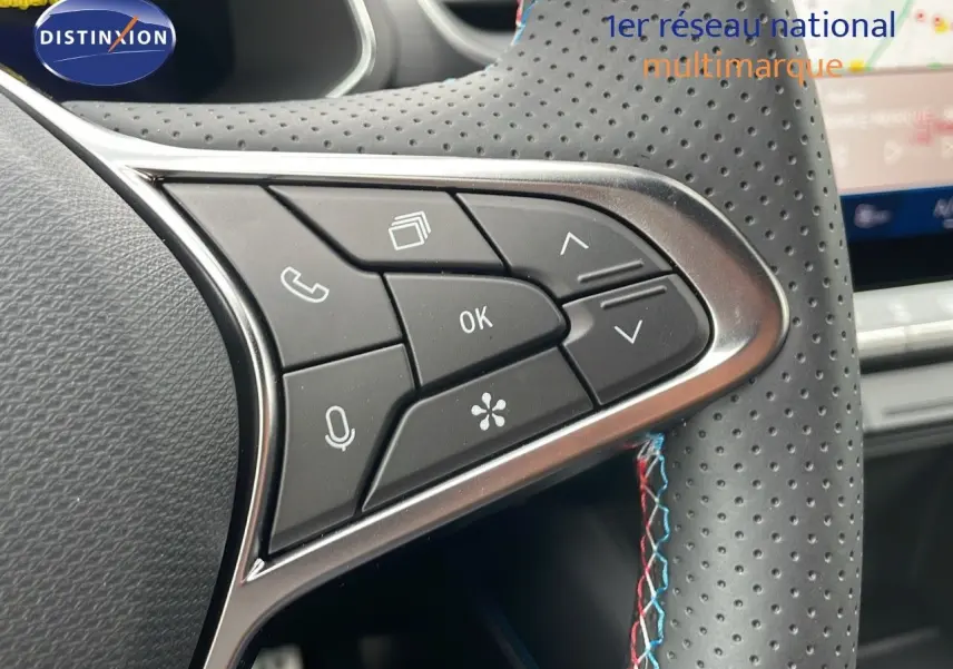 Gros plan sur les commandes du volant en cuir perforé noir avec surpiqûres tricolores du Renault Symbioz gris cassiopée métal.