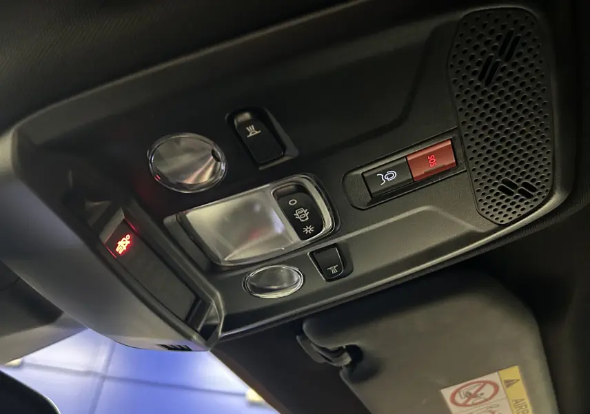 Vue intérieure en contre-plongée du plafonnier noir avec commandes d’éclairage et bouton SOS du Peugeot 2008 bleu Obsession.