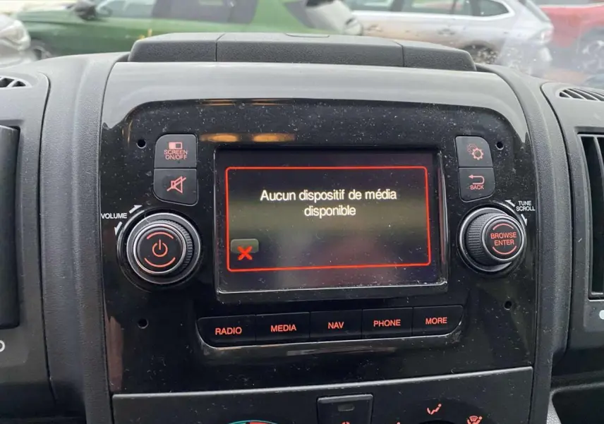 Vue rapprochée de la console centrale noire de l’Opel Movano Fourgon 2022 avec écran multimédia affichant « Aucun dispositif de média disponible ».