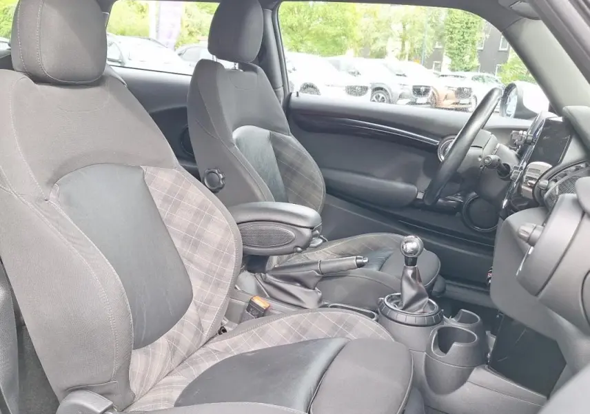 Vue intérieure côté conducteur de la MINI S John Work 2015, montrant les sièges en tissu à motif écossais et la boîte manuelle.