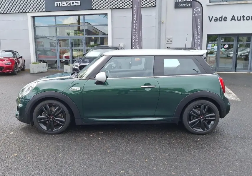 Vue de profil côté gauche d'une MINI S finition John Cooper Works 2015 verte avec toit blanc et jantes noires.