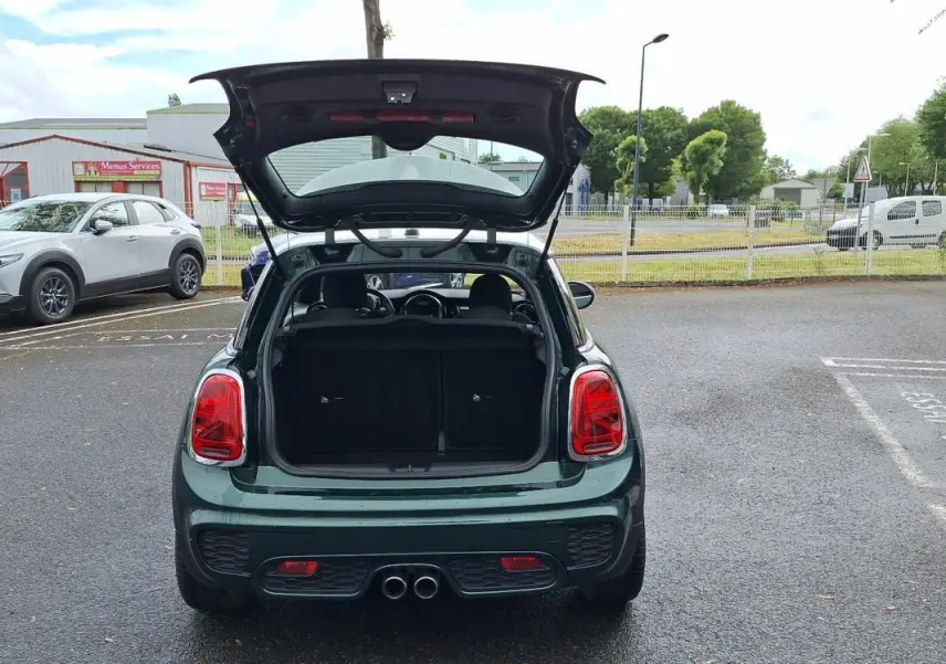 Vue arrière d'une MINI S finition John Cooper Works verte de 2015, coffre ouvert et double sortie d'échappement centrale visible.