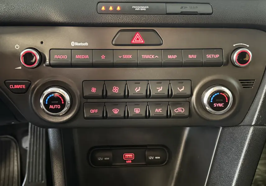 Vue rapprochée du tableau de bord du Kia Sportage gris 2019, mettant en valeur les commandes climatisation et multimédia.