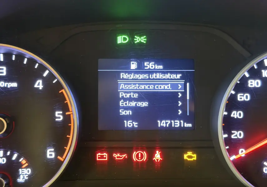 Tableau de bord du Kia Sportage 2019, affichage central avec menu utilisateur et témoins d'alerte allumés.