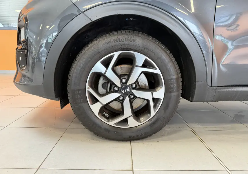Gros plan sur la roue avant gauche gris métallisé du Kia Sportage 2019 avec jante alliage et pneu Kleber.
