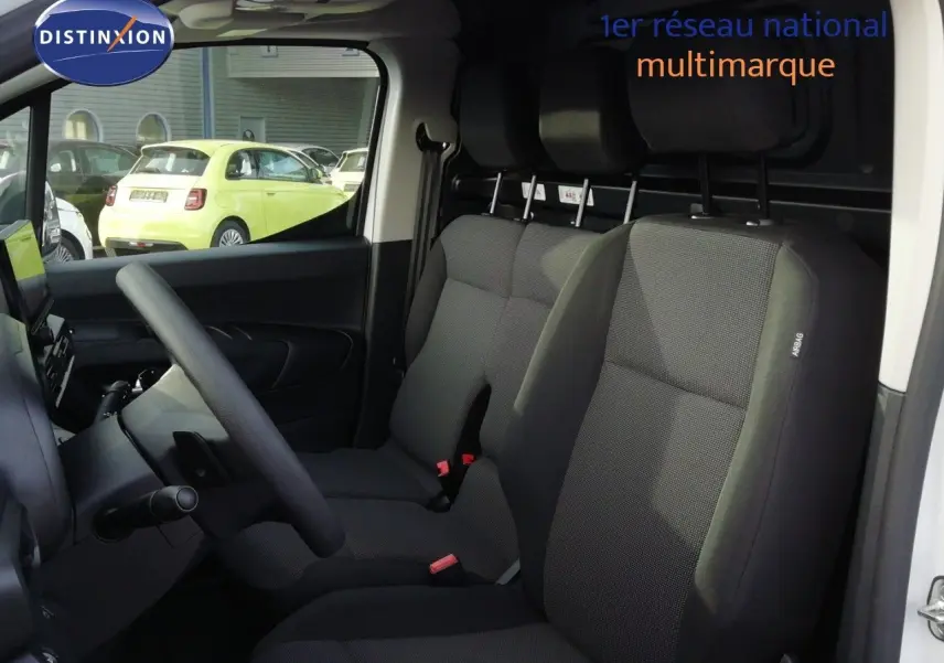 Vue intérieure côté gauche du Citroën Berlingo XL blanc Icy, montrant les sièges avant en tissu gris foncé.