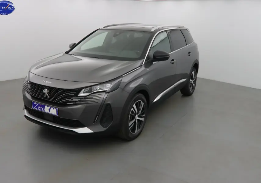 Peugeot 5008 gris platinium métal vue 3/4 avant droit, SUV moderne avec calandre noire et jantes alliage.