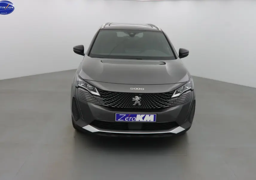 Vue frontale d'un Peugeot 5008 gris platinium métal avec calandre noire et phares LED distinctifs.
