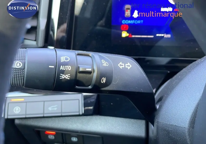 Gros plan sur la commande des feux et clignotants à gauche du volant dans l'habitacle du Renault Espace blanc nacré 2025.