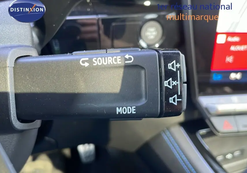 Gros plan sur la commande au volant du Renault Espace blanc nacré 2025, mettant en valeur les fonctions audio source et mode.