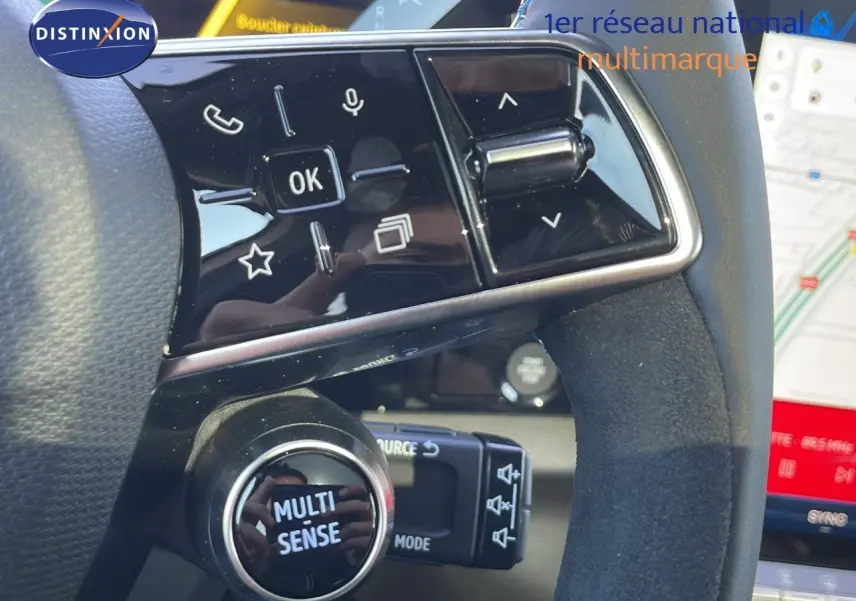 Gros plan sur le volant côté gauche du Renault Espace blanc nacré 2025, avec commandes multifonctions et bouton Multi Sense.