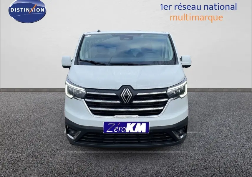 Vue de face d'un Renault Trafic Fourgon blanc glacier avec calandre noire et phares LED allumés.