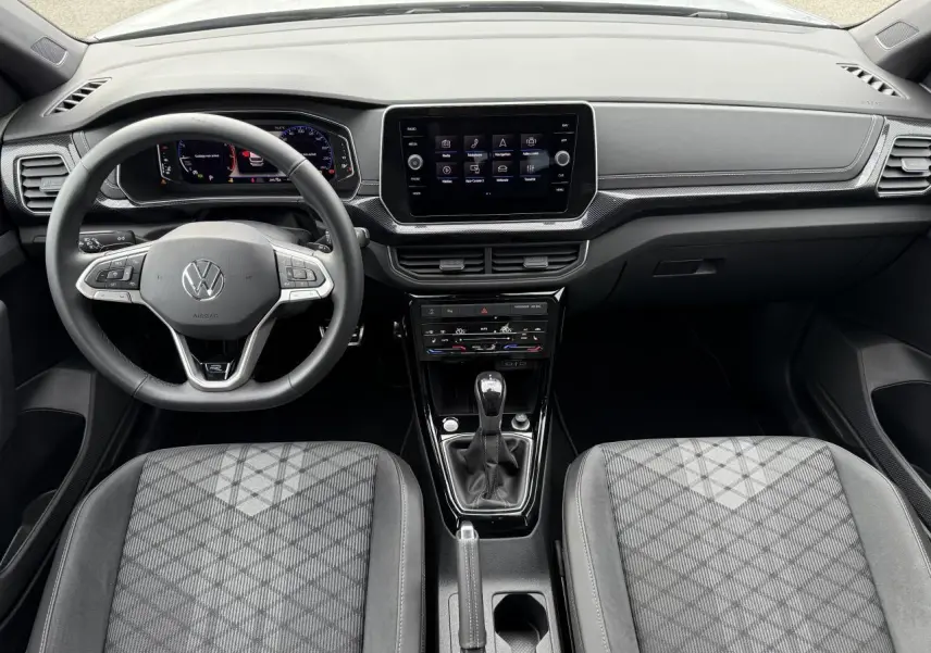 Intérieur du Volkswagen T-Cross 2025, vue frontale sur le tableau de bord et volant multifonction noir.