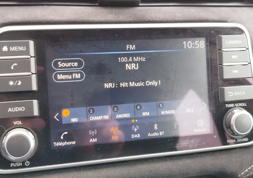 Écran tactile central de la Nissan Micra 2022 affichant la radio FM NRJ à 100,4 MHz avec commandes autour.