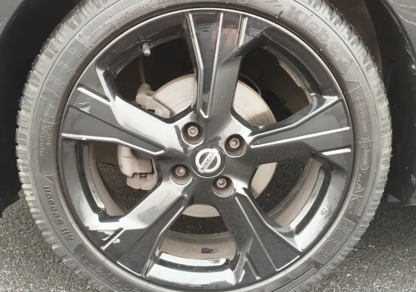 Gros plan sur la jante noire brillante de la Nissan Micra 2022, mettant en valeur le logo central et le pneu Kleber.