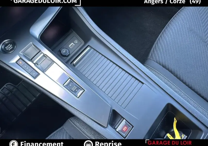 Vue rapprochée de la console centrale grise avec boîte automatique et bouton start/stop de la Peugeot 308 2023.