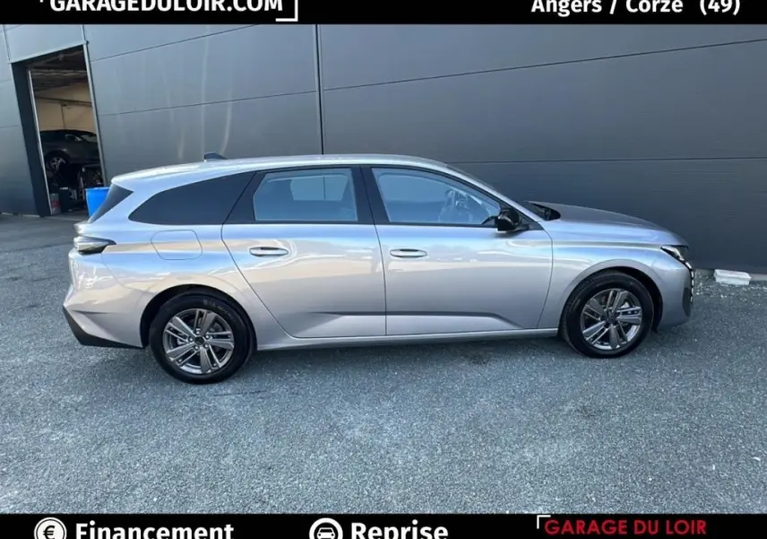 Profil droit d’une Peugeot 308 gris clair 2023, break avec jantes alliage et vitres teintées.