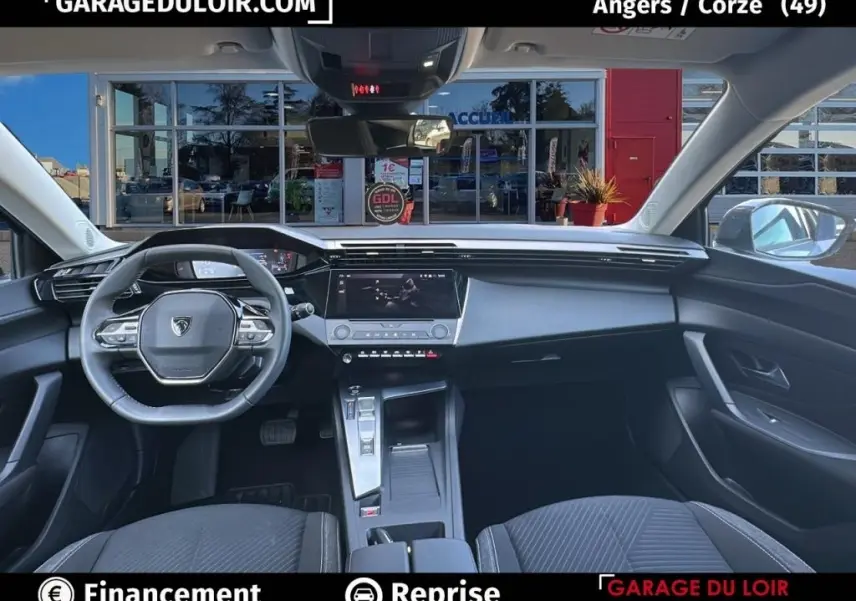 Vue intérieure avant de la Peugeot 308 gris clair 2023, avec tableau de bord digital et écran tactile central.