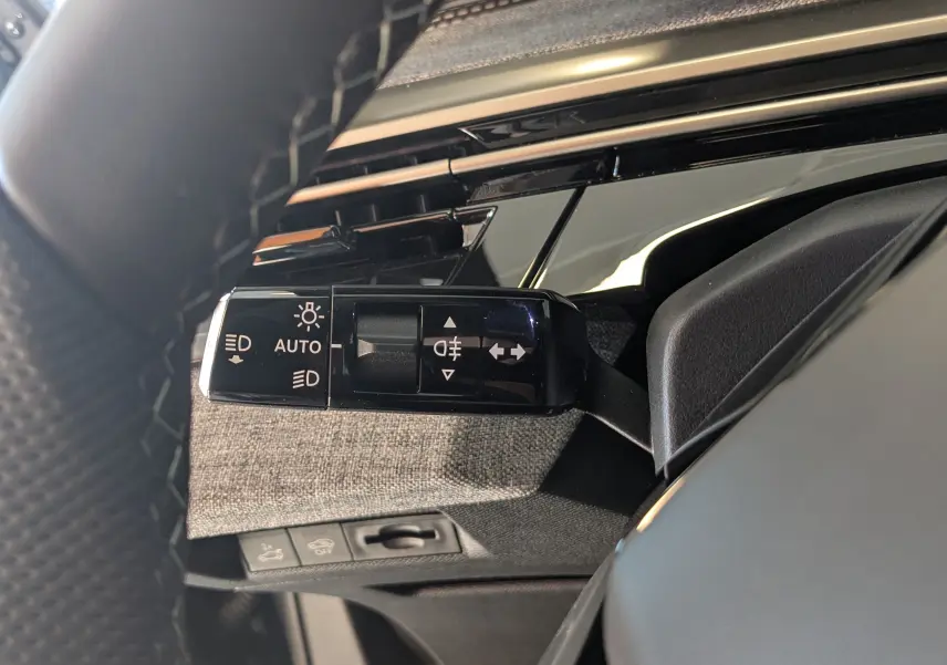 Gros plan sur la commande des phares et clignotants à gauche du volant du Peugeot 3008 bleu Ingaro 2026.