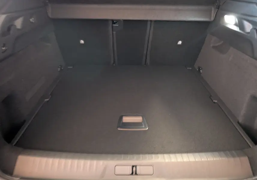 Coffre spacieux du Peugeot 3008 1.2 Hybrid 145ch GT, vue intérieure arrière avec revêtement noir uniforme.