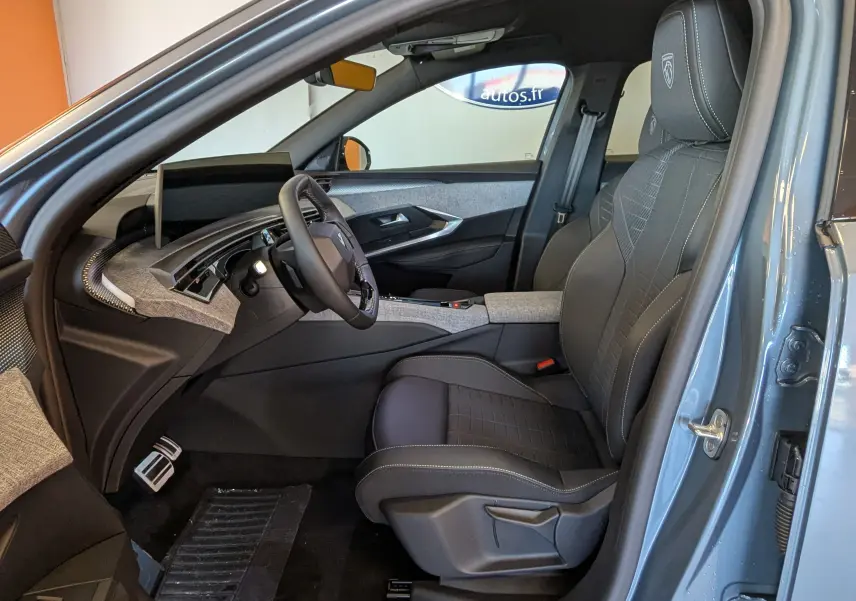 Vue intérieure côté conducteur du Peugeot 3008 bleu Ingaro, mettant en valeur le siège en cuir et le tableau de bord moderne.