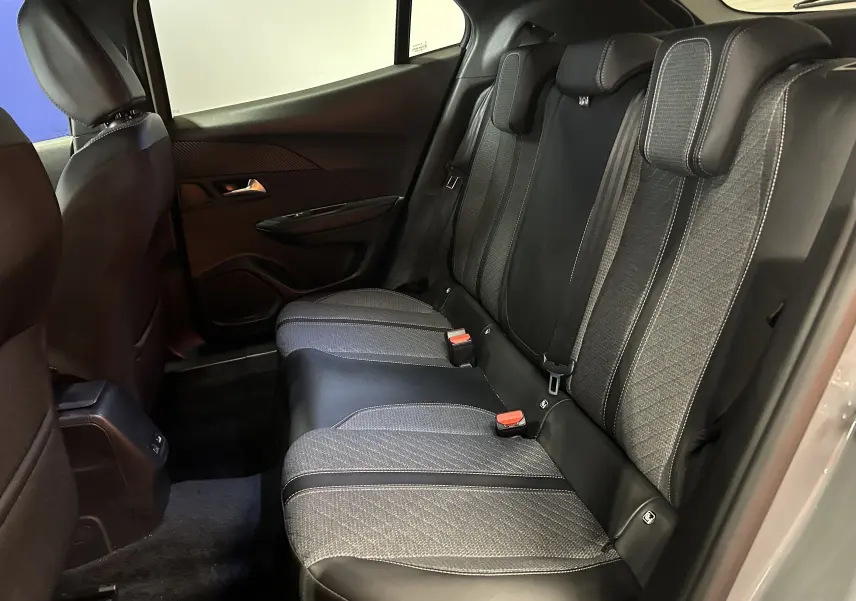 Vue intérieure côté droit des sièges arrière en tissu et cuir noir du Peugeot 2008 II Ph.2 Allure Hybrid 145 gris Selenium.