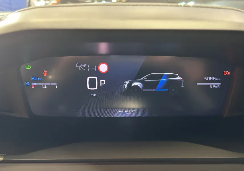 Vue rapprochée du tableau de bord numérique du Peugeot 2008 gris Selenium, affichant la vitesse, autonomie et indicateurs de conduite.
