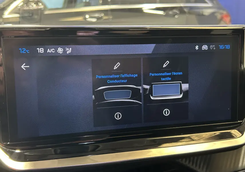 Écran tactile central de la Peugeot 2008 gris Selenium affichant les options de personnalisation du conducteur et de l'écran tactile.