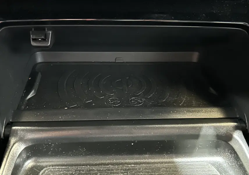 Gros plan sur le compartiment de recharge sans fil intérieur du Peugeot 2008 gris Selenium, avec prise USB visible.