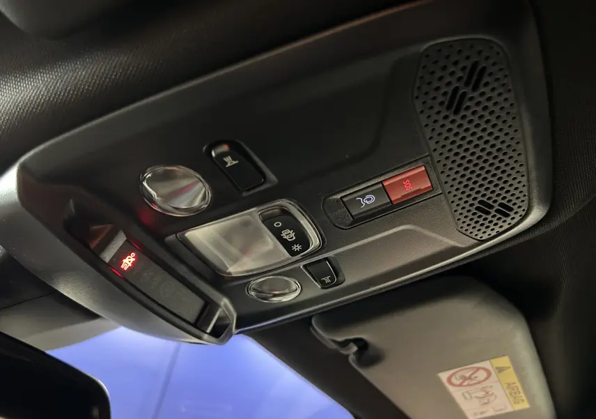 Vue intérieure en plongée du plafonnier noir avec commandes d’éclairage et bouton SOS du Peugeot 2008 gris Selenium.