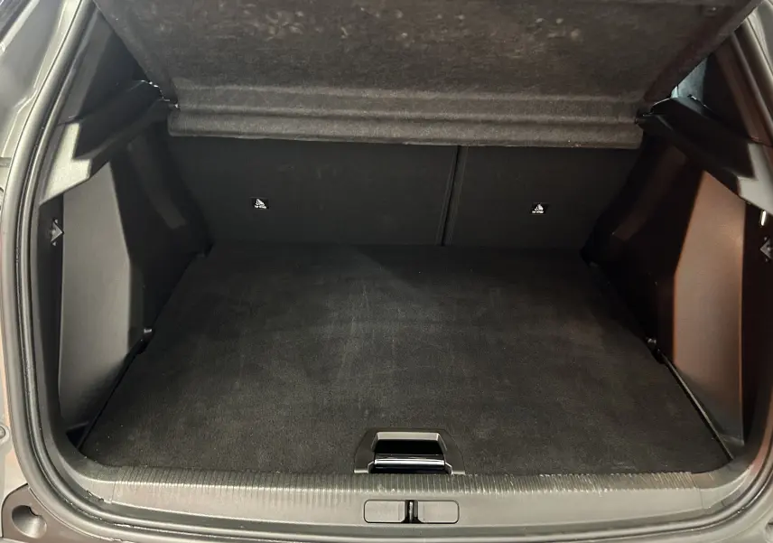 Coffre ouvert du Peugeot 2008 II Ph.2 Allure Hybrid 145 gris Selenium, vue intérieure arrière avec plancher double hauteur.