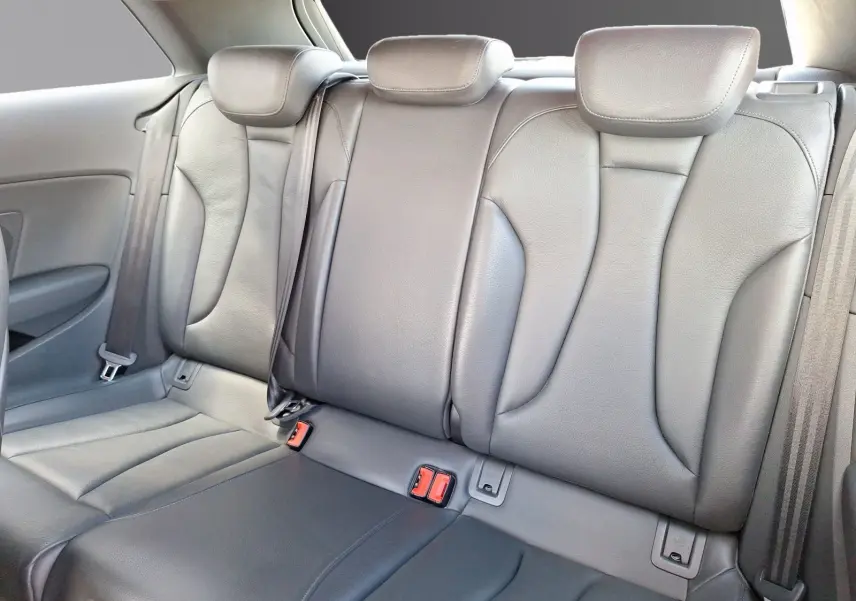 Vue rapprochée des sièges arrière en cuir gris de l'Audi A3 2017, mettant en valeur la sellerie et les ceintures de sécurité.