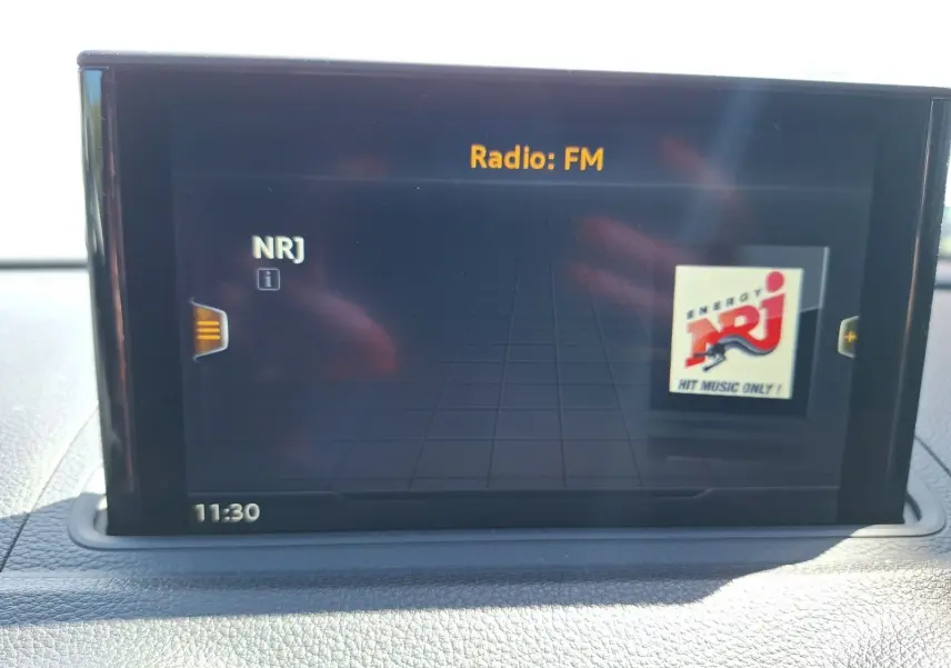 Écran central de l'Audi A3 2017 gris, affichant la radio FM NRJ avec interface numérique moderne.