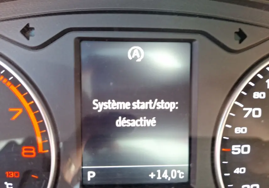 Gros plan sur l'écran du tableau de bord de l'Audi A3 gris, affichant "Système start/stop désactivé".
