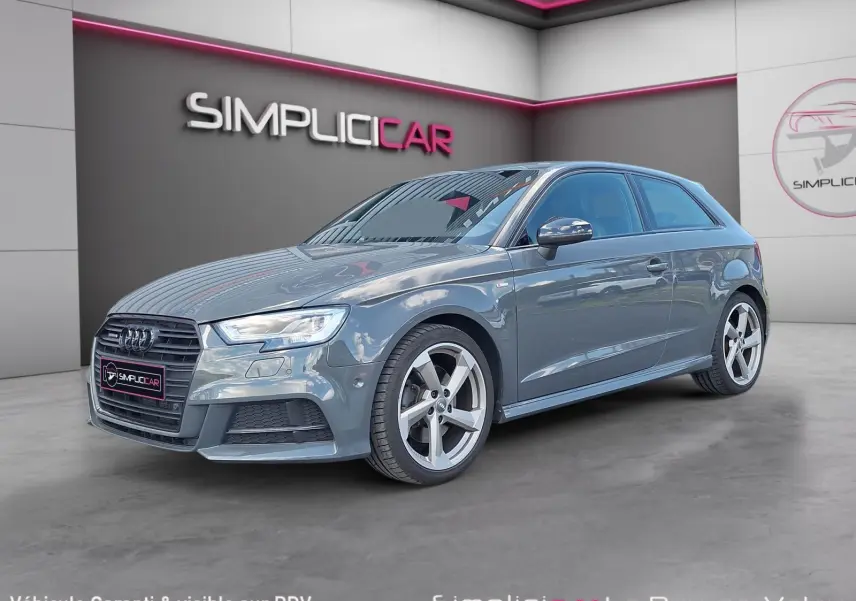 Audi A3 2.0 TFSI S Line gris en 3/4 avant droit, avec jantes alliage 18 pouces et calandre noire distinctive.