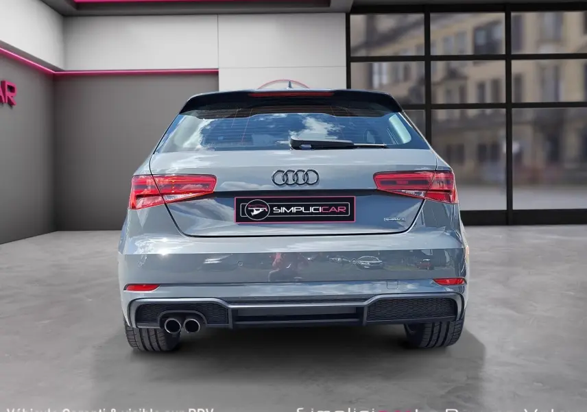 Vue arrière d'une Audi A3 gris métallisé 2017 avec double sortie d'échappement et badge Quattro visible.