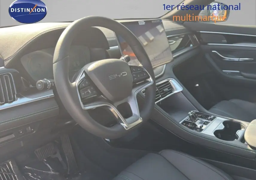 Intérieur du BYD SEAL U 2026 en vue côté conducteur, volant multifonction et écran tactile central visibles.