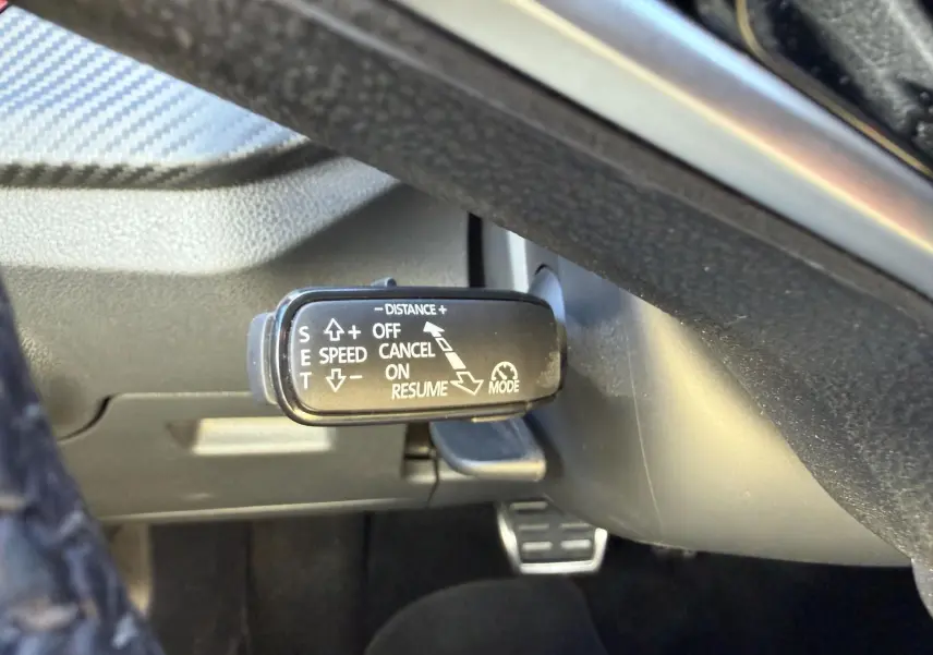 Gros plan sur la commande du régulateur de vitesse adaptatif sous le volant du Skoda Kamiq 2025.